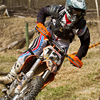 a guy leaning into a corner riding a dirt bike