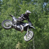 A man flies through the air on his dirt bike.
