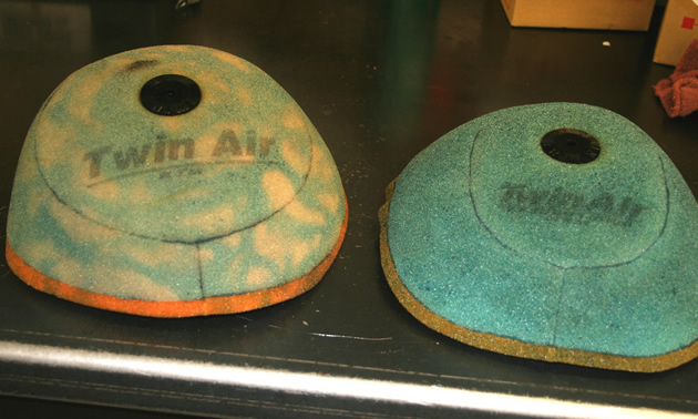 Two air filters placed beside each other. One is pure blue in colour and the other one is spotted. 