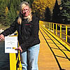 Woman standing on a wooden bridge over a river in the backcountry