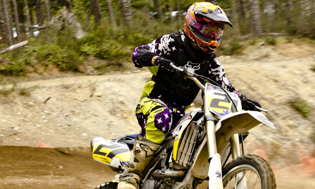 Photo of a guy riding a yellow dirt bike. 