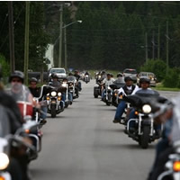 A big group of motorcyclists riding down the highway. 