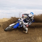 A man kicks up dirt on his motorbike.