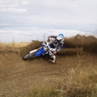 A man kicks up dirt on his motorbike