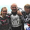 three people wearing riding gear and smiling