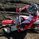 Photo looking down on a motocrosser riding a red dirt bike. 