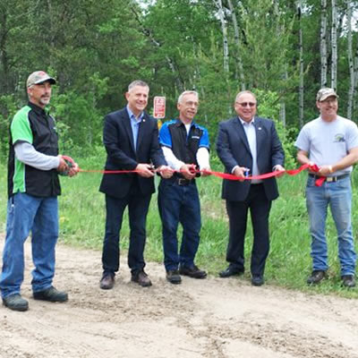 Members of the Eastman ATV Association cutting the ribbon at the grand opening of the Eastman ATV Trail in Sandilands Provincial Forest. 