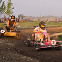 Three people riding around a track on go-carts. 