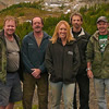 Five people stand on top of a mountain