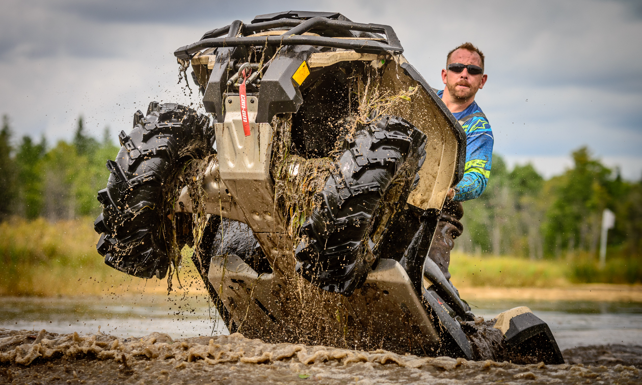 Barrie Martelle does a wheelie in mud on his 2022 Can-Am Outlander XMR 1000. 