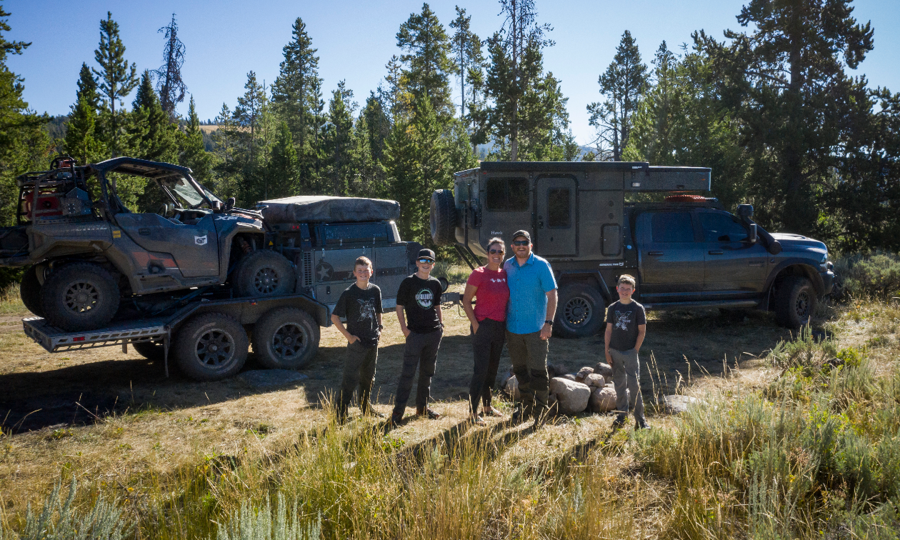 (L to R) Ryder, Cyrus, Rachelle, Clay and Eli Croft stand in front of their Dodge Ram 3500, carrying a Patriot Camper TH610 trailer with a Polaris General 1000.