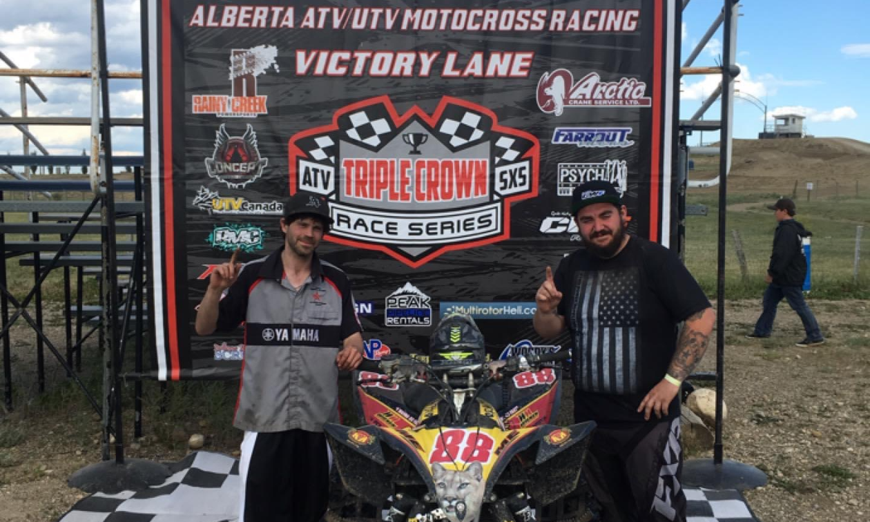 Roy Eakett and Jason Stapleton hold up their index fingers to indicate that they placed #1 in the 2018 Alberta ATV Triple Crown series. 