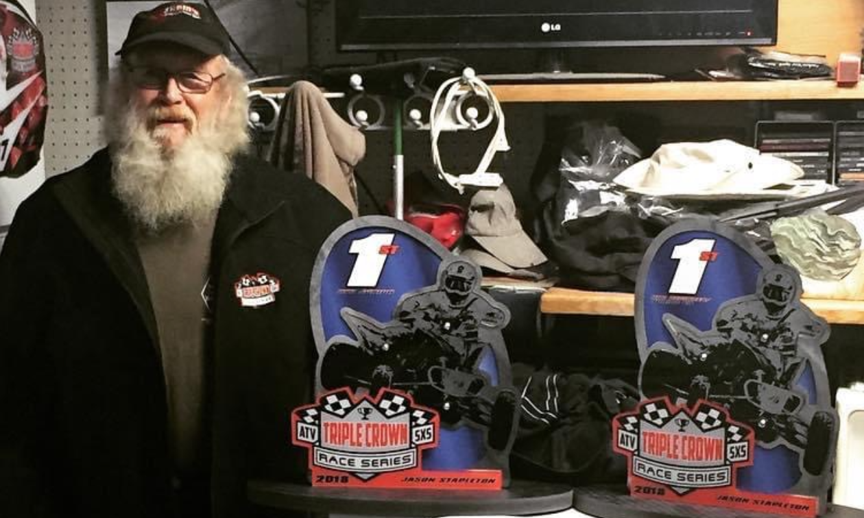 Jason Stapleton’s grandfather poses next to two Alberta ATV Triple Crown series championship trophies. 