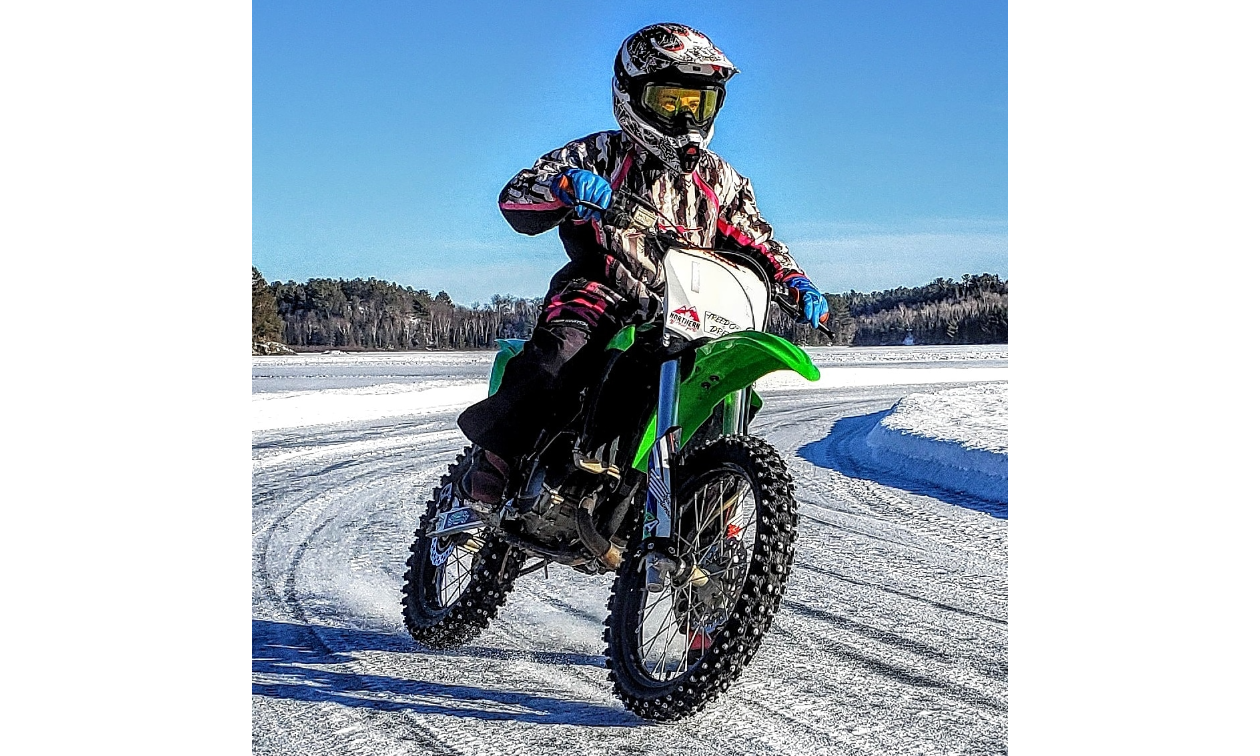 Jessica Rainville rides a green dirt bike on an icy track.