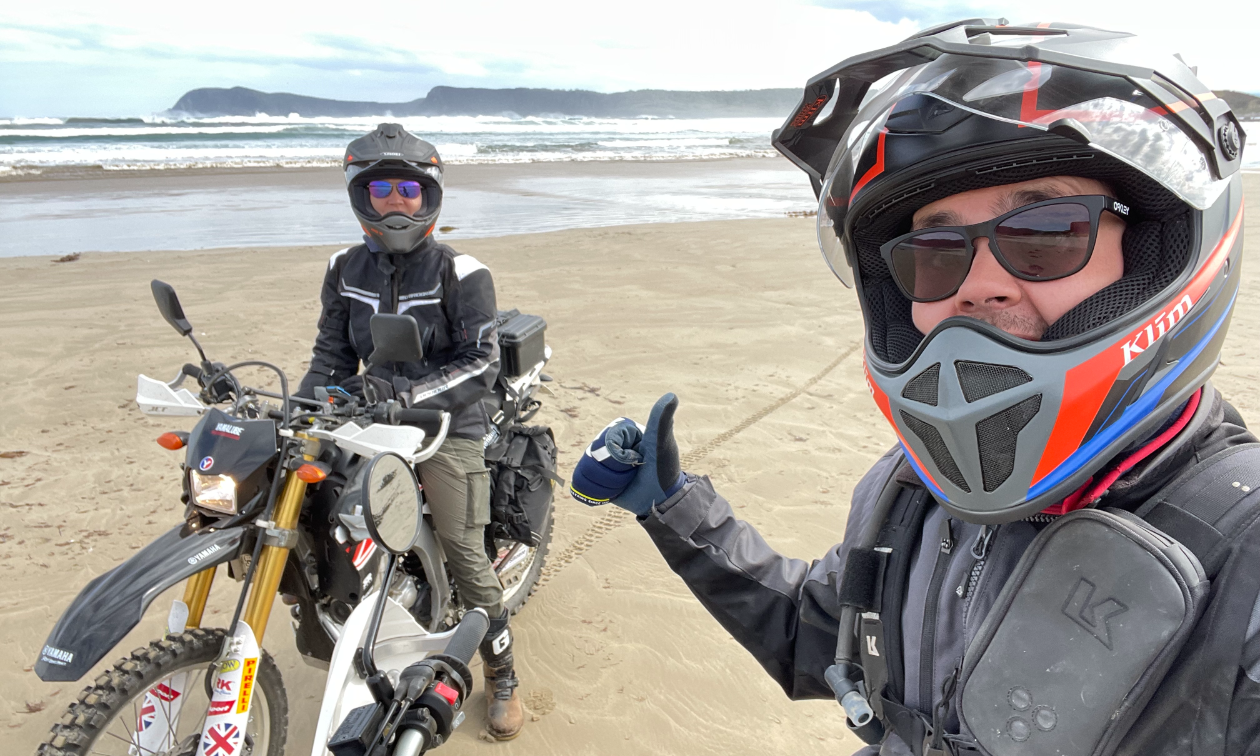 Kevin Chow gives a thumbs up while sitting on his motorbike next to Claire Newbolt on another motorbike on the sands of Australia’s east coast. 