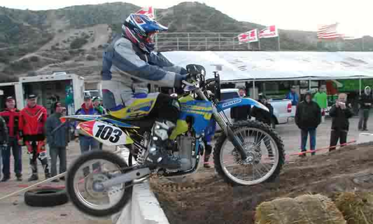 Lee Fryberger rides a motorcycle over a barricade during a competition. 