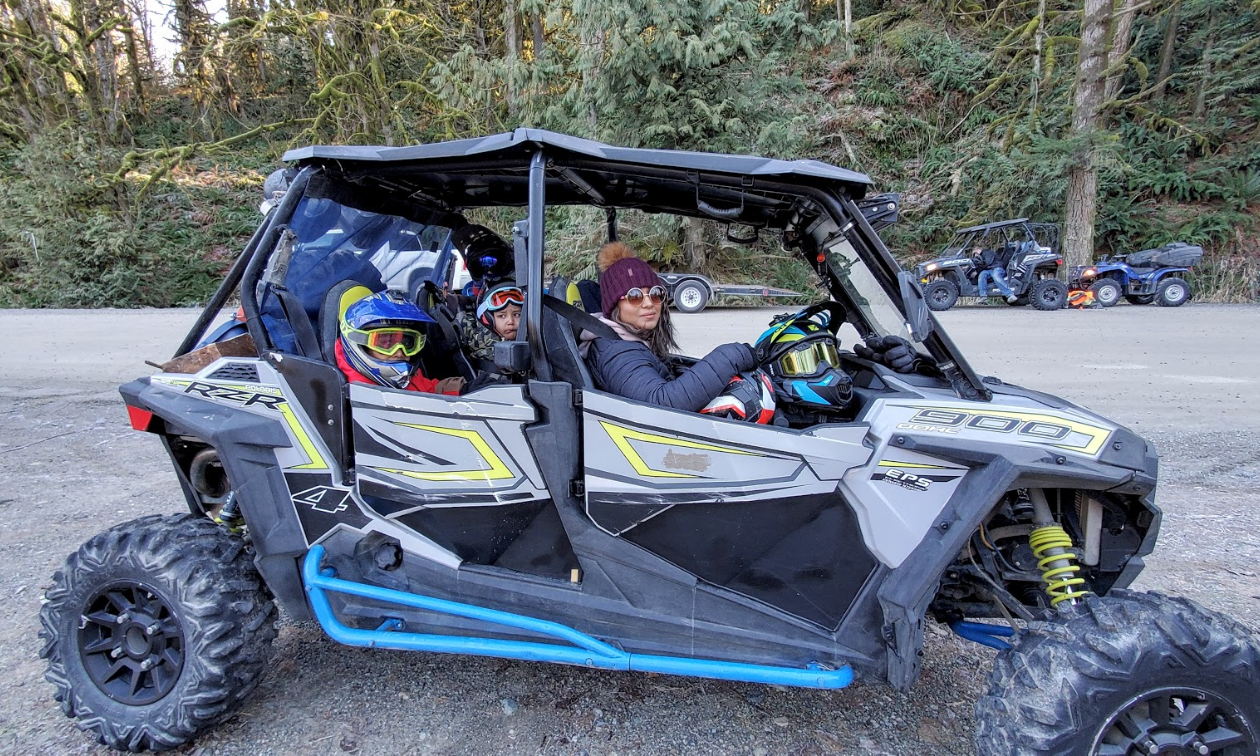 A woman and two children sit in a 2018 Polaris RZR S4 900. 