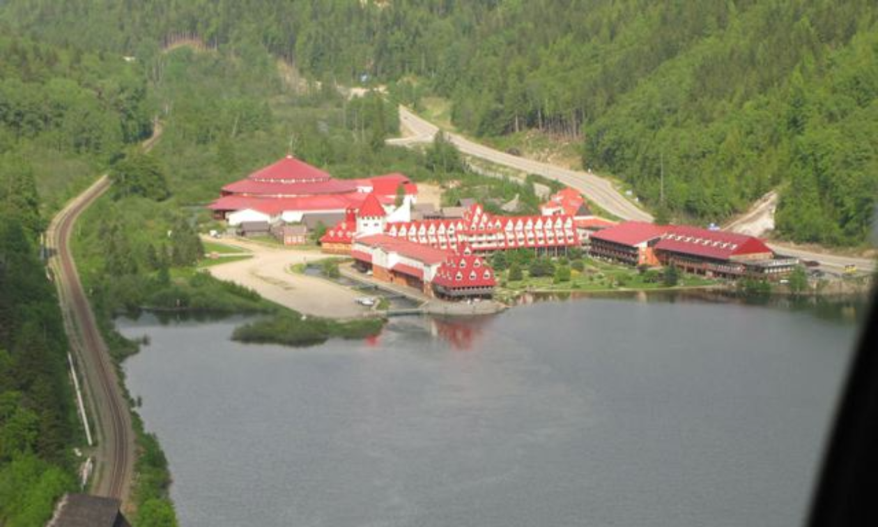 The Three Valley Gap resort has red roofs and is right on a lake.