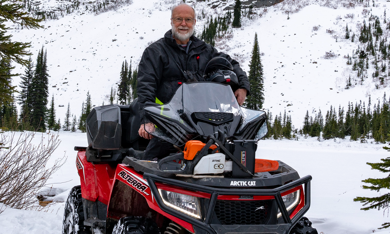 Wayne Mercer sits on his red and black 2017 Arctic Cat Alterra XT TRV 1000 on shallow snow. 