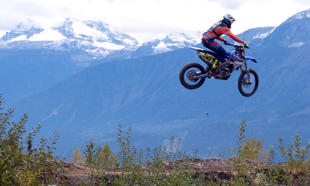 Dirt biker flying high in the air at the Revy Riders motocross track. 
