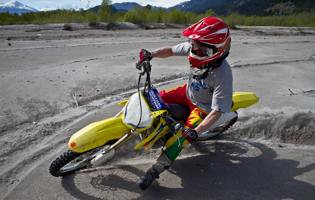 Sean Nicol spins donuts on his dirt bike in the sand. 