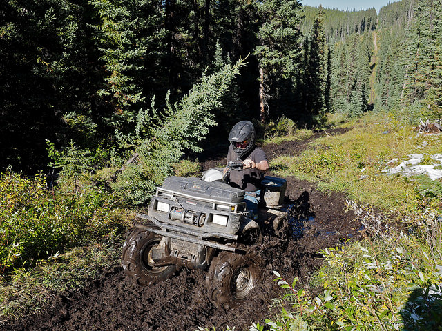 Shirley Arnold makes her Polaris 550 work a little getting her through the mud on a trail in Tay River area.