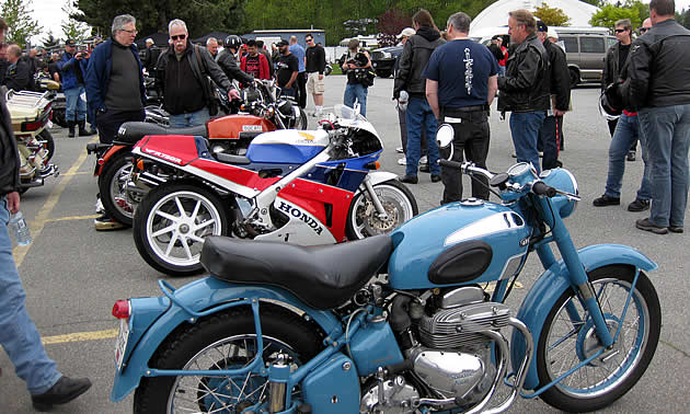Vintage motorcycles in a parking lot. 