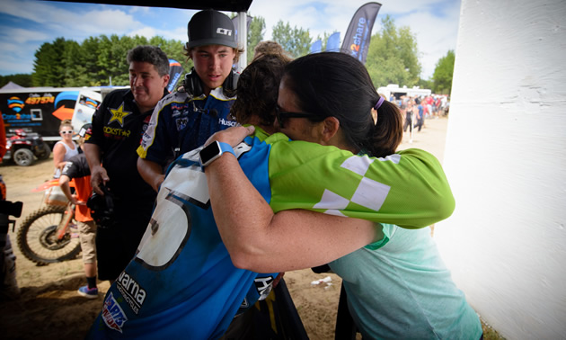 Tyler Medaglia's mom hugging him on the podium after a race. 