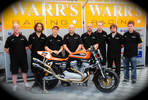 Darren James standing with members of the Warr's Harley-Davidson racing team. 