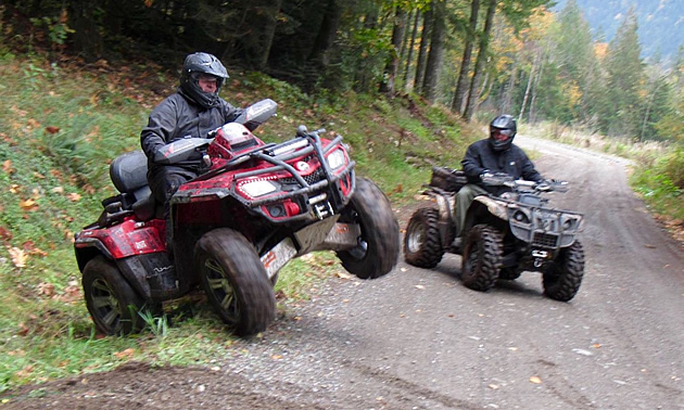 Two ATVers riding on a Forest Service Road. 