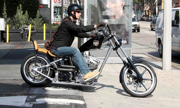 Keanu Reeves riding a chopper motorcycle. 