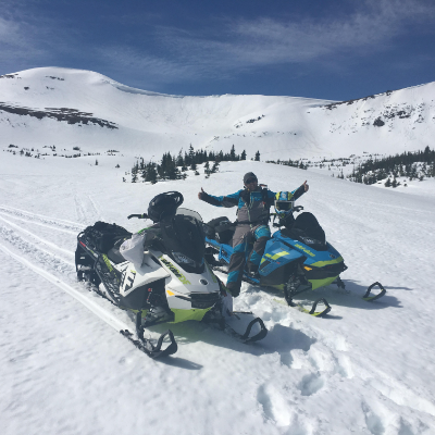 Allan Bouchard smiles on his snowmobile in the backcountry.