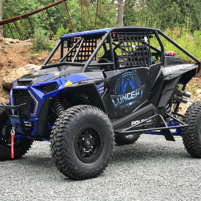 A blue UTV has black Nerf Bars that protrude from the lower side and rear of the vehicle to protect it.
