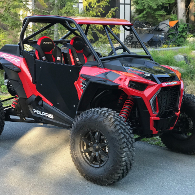 A red UTV has a fashionable canopy and roll cage around its frame.