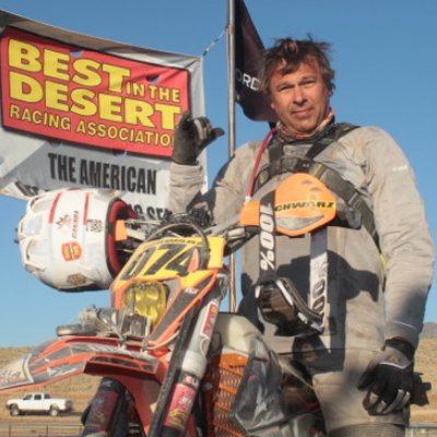 Florian Schwarz poses under a banner for the Best in the Desert Vegas to Reno race.