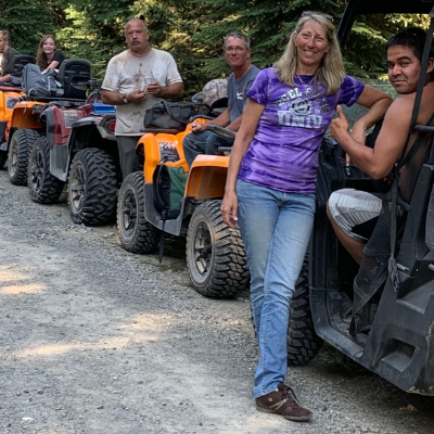 A row of ATVs line up on a trail.