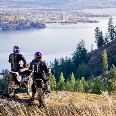 Motorcyclists look out at Kelowna from a high point