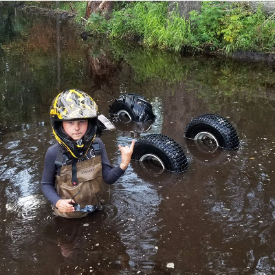 Taigen poses next to an overturned ATV
