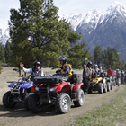 A group of ATVers lined up with mountains in background. 