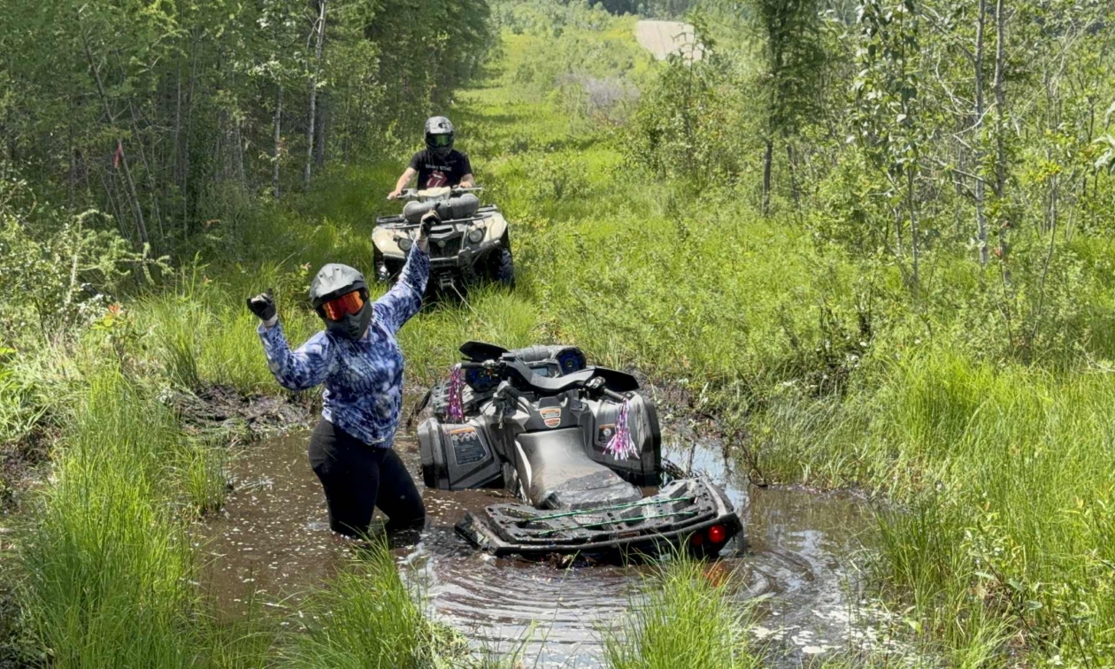 people riding ATVs through muddy terrain