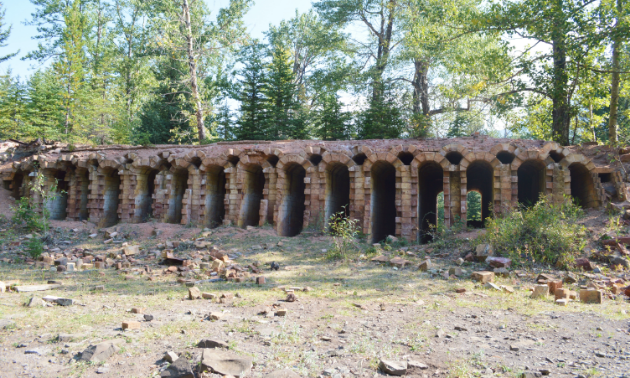 Dilapidated coke ovens have narrow arches between slits of bricks.