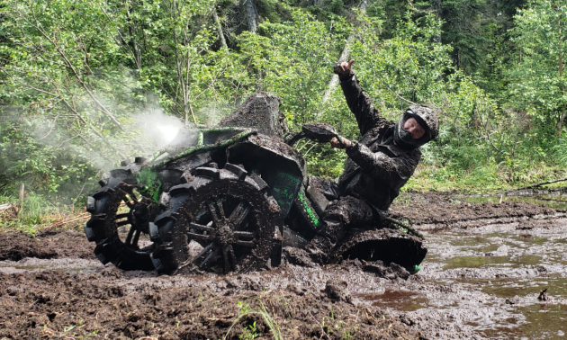 Chris Black gives a thumbs-up as he plows his way out of a large mudpuddle.