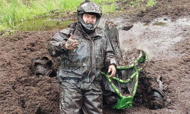 Chris Black gives a thumbs-up while covered in mud next to his 2012 Can Am Renegade XXC 1000.
