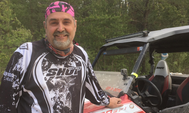 Don Lemoine smiles while leaning up against his 2011 Polaris RZR S side-by-side.