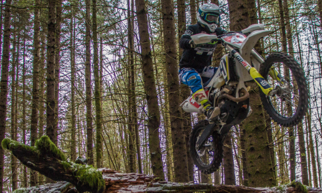 Dustin Labby leaps over a fallen tree on his motorbike.