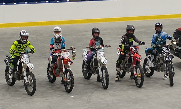 Five dirt bikers line up to take turns competing to be crowned champion.