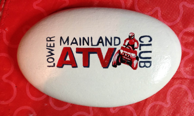 A painted rock of the Lower Mainland ATV Club’s logo.