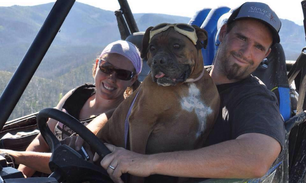 Lisa and Nathan Block smile from within their 2015 Polaris 900 RZR while their boxer Brooklyn sits on Nathan’s lap.