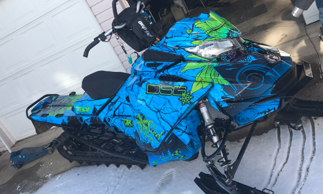 A striking blue and green snowmobile. 