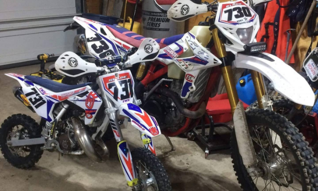 A matching set of dirt bikes, albeit different sizes, with white, blue and red paint jobs.